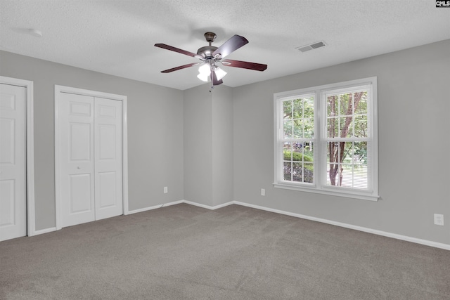 325 Trinity Three Rd, Irmo, SC 29063 - unfurnished bedroom with a textured ceiling, carpet, two closets, and a ceiling fan
