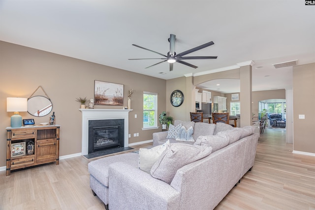 634 Bluff Pointe, Columbia, SC 29212 - living area with light wood-style flooring, arched walkways, ceiling fan, and a glass covered fireplace
