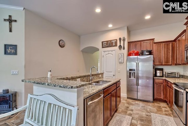 1817 Crystal Ln, West Columbia, SC 29170 - kitchen with appliances with stainless steel finishes, arched walkways, light stone countertops, a wood stove, and recessed lighting