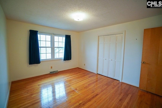 114 Robinson, North, SC 29112 - unfurnished bedroom with light wood finished floors, a closet, and a textured ceiling