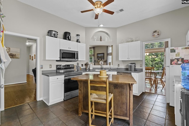 115 Black Creek Ln, Irmo, SC 29063 - kitchen with appliances with stainless steel finishes, a ceiling fan, white cabinets, a center island, and a breakfast bar area