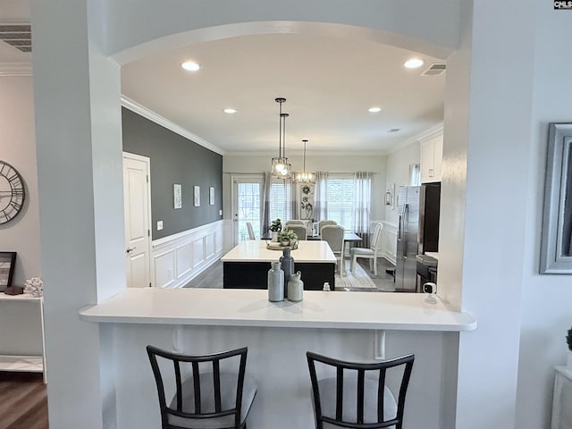 122 Tannery Way, Lexington, SC 29073 - kitchen with a center island, stainless steel fridge, arched walkways, crown molding, and light countertops