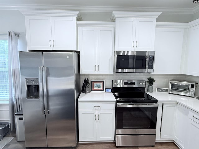 122 Tannery Way, Lexington, SC 29073 - kitchen featuring appliances with stainless steel finishes, white cabinets, decorative backsplash, and ornamental molding
