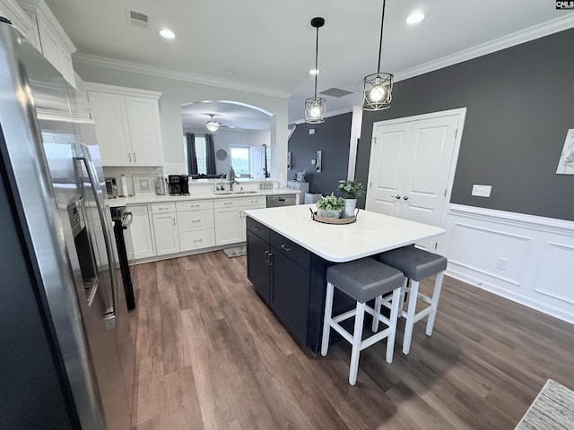 122 Tannery Way, Lexington, SC 29073 - kitchen with stainless steel appliances, light countertops, a center island, white cabinets, and ornamental molding