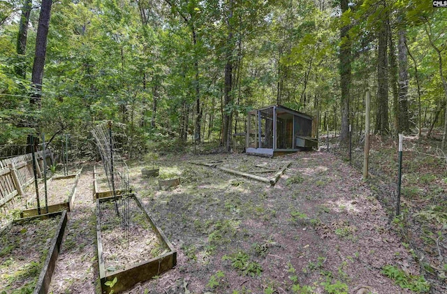 1208 Peacehaven Rd, Chapin, SC 29036 - view of yard featuring a vegetable garden, an outbuilding, a wooded view, and exterior structure