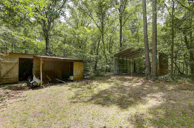 1208 Peacehaven Rd, Chapin, SC 29036 - view of yard with a detached carport, an outbuilding, and a view of trees