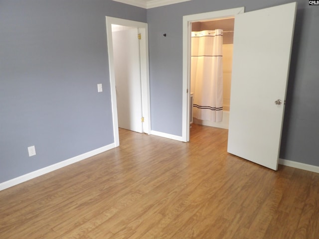 1016 Willis St, Batesburg, SC 29006 - unfurnished bedroom with light wood-type flooring, ornamental molding, and freestanding refrigerator