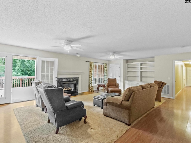 302 Brown St, Prosperity, SC 29127 - living area featuring a textured ceiling, wood finished floors, a fireplace, ceiling fan, and built in shelves
