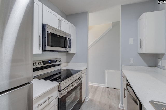 1320 Piney Grove Rd Unit 3C, Columbia, SC 29210 - kitchen with appliances with stainless steel finishes, light wood-type flooring, white cabinetry, and light countertops