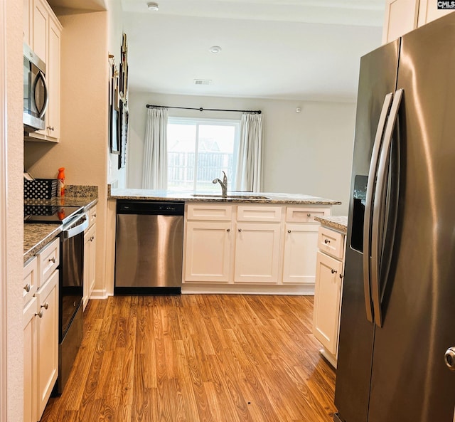 1406 Native Garden Rd, Gilbert, SC 29054 - kitchen featuring appliances with stainless steel finishes, light wood-style flooring, white cabinets, and light stone counters
