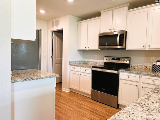 1406 Native Garden Rd, Gilbert, SC 29054 - kitchen featuring stainless steel appliances, light wood finished floors, white cabinetry, recessed lighting, and light stone counters
