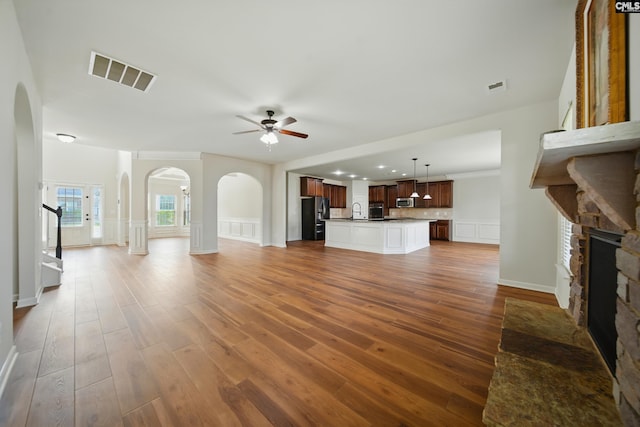 129 River Bridge Ln, Lexington, SC 29073 - unfurnished living room featuring arched walkways, a fireplace, ceiling fan, wood finished floors, and recessed lighting