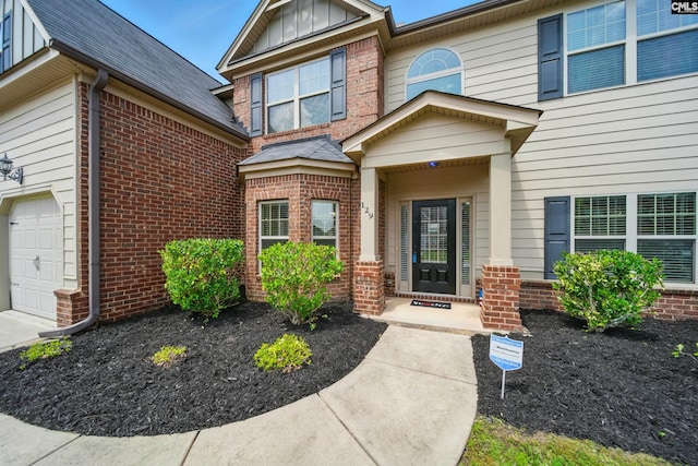 129 River Bridge Ln, Lexington, SC 29073 - view of exterior entry featuring brick siding, an attached garage, and a shingled roof