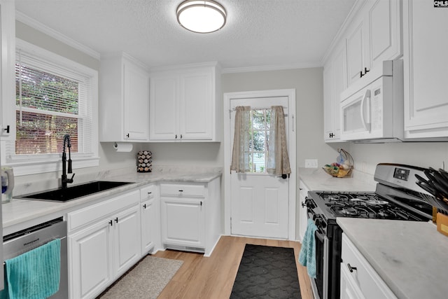 1715 Lacy St, Columbia, SC 29169 - kitchen featuring appliances with stainless steel finishes, a textured ceiling, light wood-type flooring, light countertops, and white cabinetry