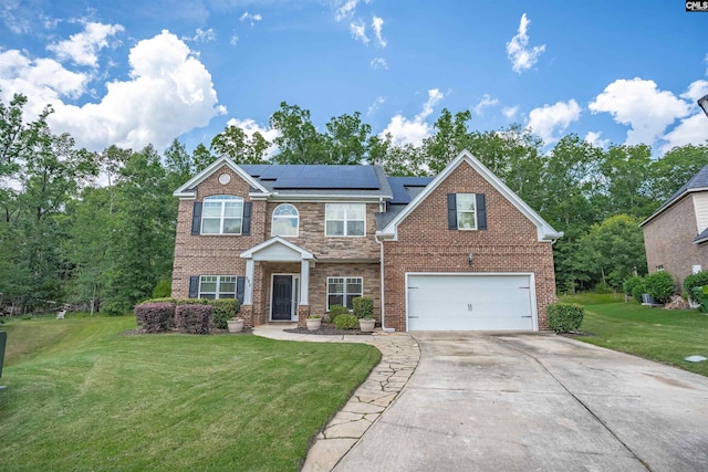 699 Village Market Dr, Chapin, SC 29036 - traditional-style home featuring concrete driveway, a front yard, roof mounted solar panels, an attached garage, and brick siding