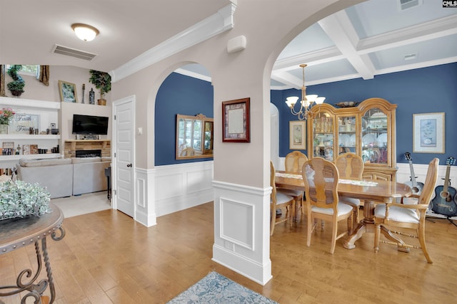 699 Village Market Dr, Chapin, SC 29036 - dining room with light wood-style floors, beam ceiling, arched walkways, crown molding, and wainscoting