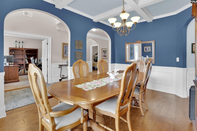 699 Village Market Dr, Chapin, SC 29036 - dining area featuring arched walkways, a chandelier, beam ceiling, hardwood / wood-style floors, and a wainscoted wall