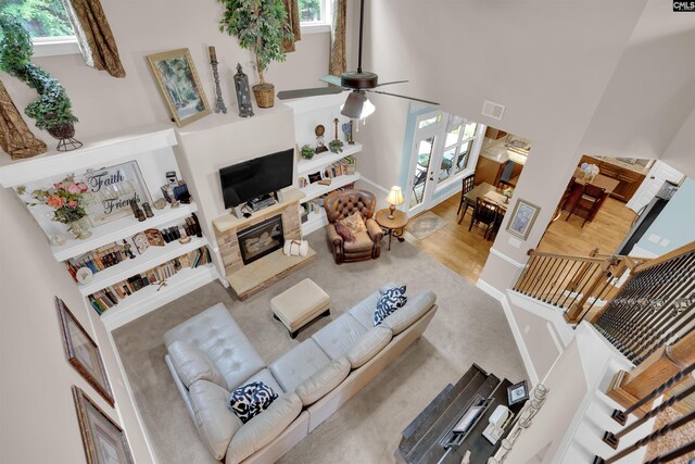 699 Village Market Dr, Chapin, SC 29036 - living room featuring a high ceiling, plenty of natural light, a glass covered fireplace, a ceiling fan, and built in shelves