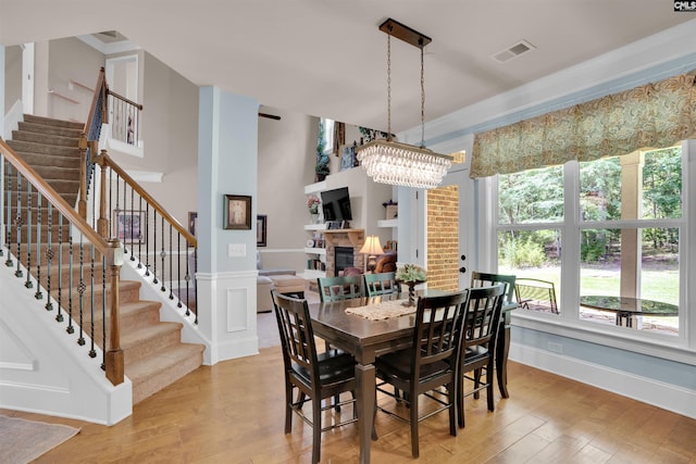 699 Village Market Dr, Chapin, SC 29036 - dining room with a stone fireplace, light wood finished floors, stairway, and a chandelier