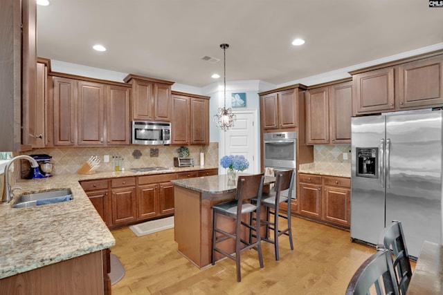699 Village Market Dr, Chapin, SC 29036 - kitchen featuring appliances with stainless steel finishes, backsplash, light stone countertops, a breakfast bar area, and a kitchen island