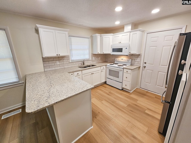 1712 Omarest Dr, Columbia, SC 29210 - kitchen with white appliances, a peninsula, white cabinetry, backsplash, and recessed lighting