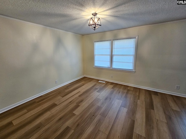 1712 Omarest Dr, Columbia, SC 29210 - empty room featuring a textured ceiling, a chandelier, dark wood finished floors, and ornamental molding