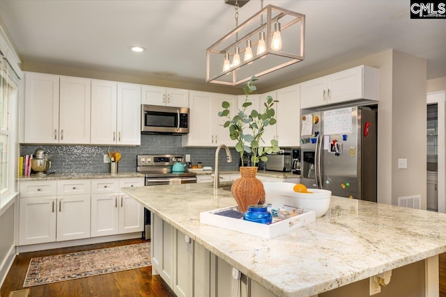 3139 Travis Ct, Columbia, SC 29204 - kitchen with stainless steel appliances, dark wood-style floors, white cabinetry, recessed lighting, and a kitchen island with sink