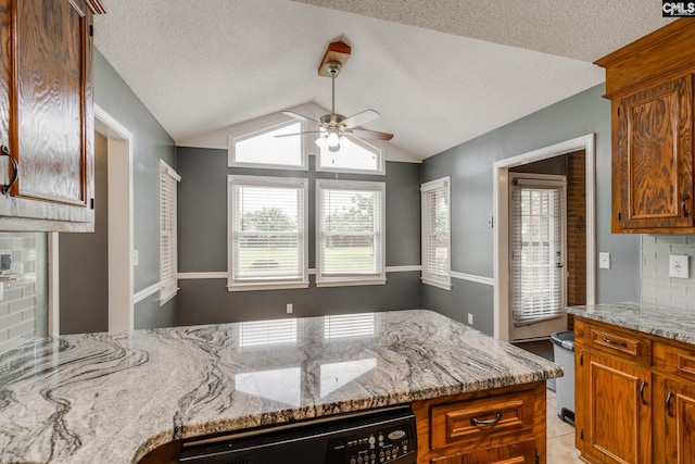 40 Stonehedge Ct, Sumter, SC 29154 - kitchen featuring dishwashing machine, a ceiling fan, lofted ceiling, light stone counters, and a textured ceiling