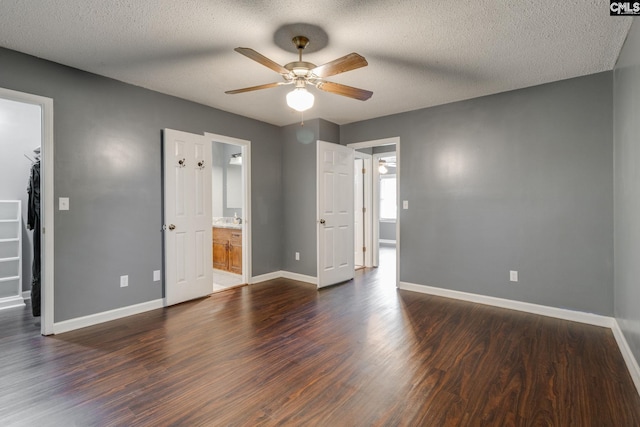 40 Stonehedge Ct, Sumter, SC 29154 - unfurnished bedroom with a spacious closet, dark wood finished floors, a textured ceiling, ensuite bathroom, and a ceiling fan