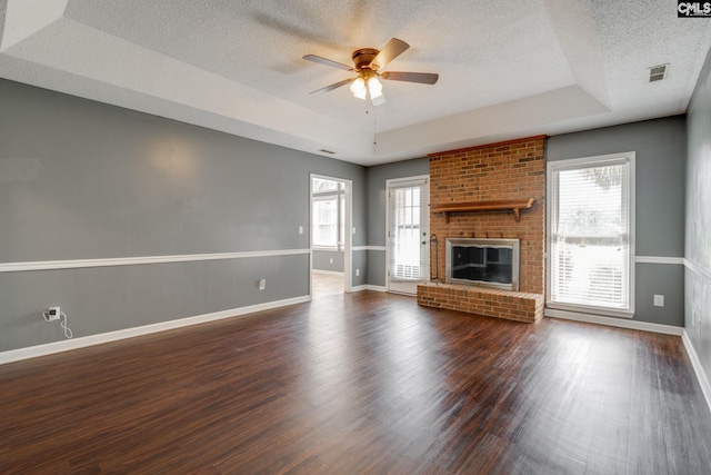 40 Stonehedge Ct, Sumter, SC 29154 - unfurnished living room with ceiling fan, a tray ceiling, dark wood-type flooring, a textured ceiling, and healthy amount of natural light