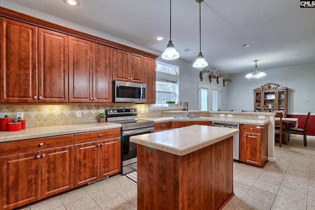 360 Twisting Rd, Lexington, SC 29072 - kitchen featuring stainless steel appliances, a peninsula, tasteful backsplash, light countertops, and a kitchen island