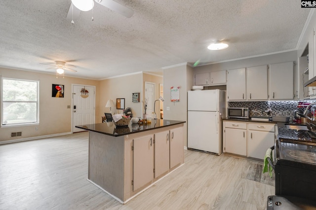 255 Sunnydale Dr, Columbia, SC 29223 - kitchen with freestanding refrigerator, ceiling fan, stainless steel microwave, dark countertops, and a textured ceiling