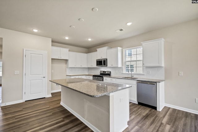259 Backspin Dr, Elgin, SC 29045 - kitchen featuring appliances with stainless steel finishes, dark wood-style floors, a kitchen island, white cabinets, and recessed lighting