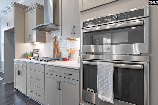 2340 Hadley Xing, Chapin, SC 29036 - kitchen featuring appliances with stainless steel finishes, wall chimney range hood, backsplash, light countertops, and dark wood-style flooring
