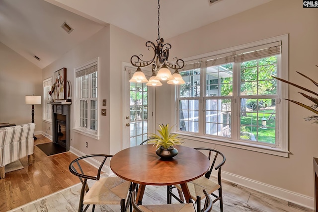 305 W Ashford Way, Irmo, SC 29063 - dining room with vaulted ceiling, a glass covered fireplace, a chandelier, and light wood-type flooring