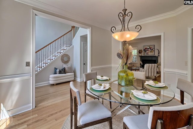 305 W Ashford Way, Irmo, SC 29063 - dining area with stairs, crown molding, light wood-style flooring, and a fireplace