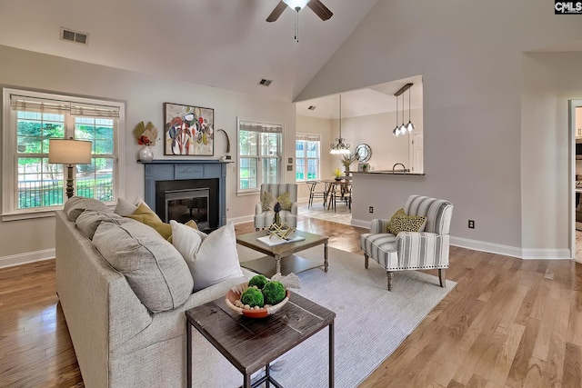 305 W Ashford Way, Irmo, SC 29063 - living area with a ceiling fan, a glass covered fireplace, wood finished floors, high vaulted ceiling, and a chandelier