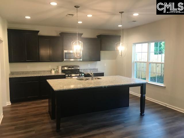 1351 Tamarind Ln, Chapin, SC 29036 - kitchen featuring appliances with stainless steel finishes, light stone countertops, an island with sink, recessed lighting, and a chandelier
