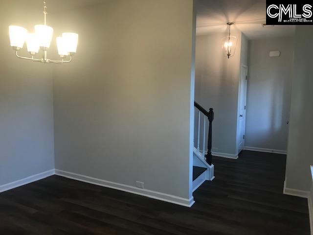 1351 Tamarind Ln, Chapin, SC 29036 - unfurnished dining area featuring a chandelier, dark wood-style floors, and stairway
