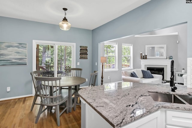 1040 Night Harbor Cir, Chapin, SC 29036 - kitchen featuring light wood-style floors, white cabinetry, hanging light fixtures, and healthy amount of natural light