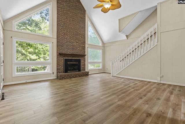 242 Arrow Shores Rd, Chapin, SC 29036 - unfurnished living room with high vaulted ceiling, a ceiling fan, stairs, wood finished floors, and a fireplace