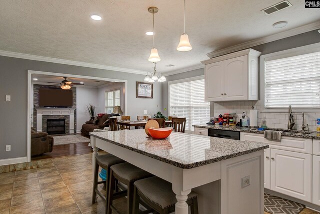 7 Chickasaw Cir, Columbia, SC 29229 - kitchen featuring ceiling fan, a breakfast bar, a center island, white cabinetry, and a textured ceiling