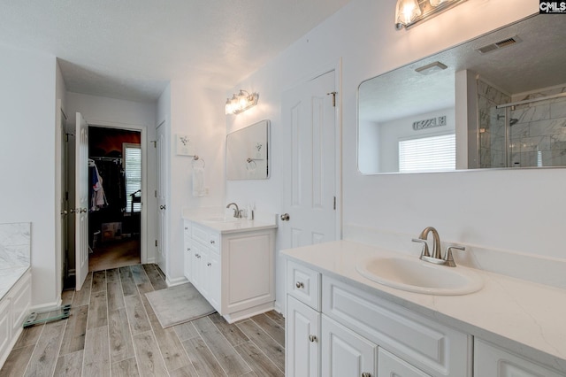 7 Chickasaw Cir, Columbia, SC 29229 - full bath with a stall shower, two vanities, wood finished floors, a walk in closet, and a textured ceiling
