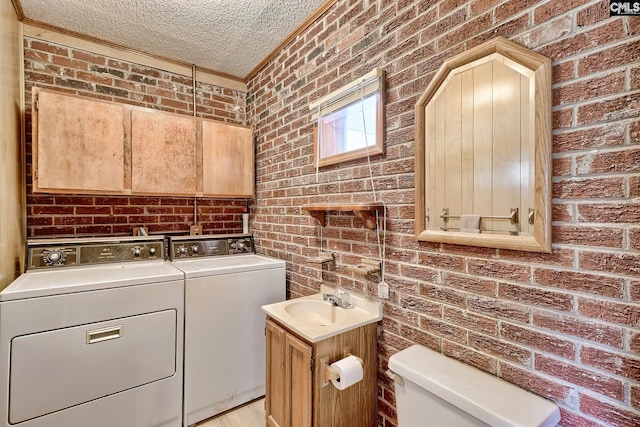 1700 Cermack St, Columbia, SC 29223 - laundry room featuring independent washer and dryer, brick wall, a textured ceiling, and crown molding