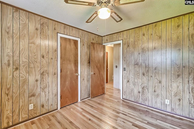 1700 Cermack St, Columbia, SC 29223 - unfurnished bedroom with light wood-style flooring, wooden walls, a textured ceiling, ornamental molding, and a ceiling fan