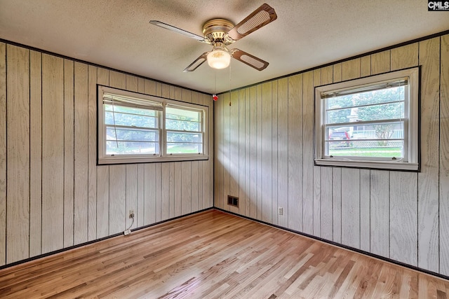 1700 Cermack St, Columbia, SC 29223 - unfurnished room with light wood finished floors, a textured ceiling, wooden walls, and a ceiling fan