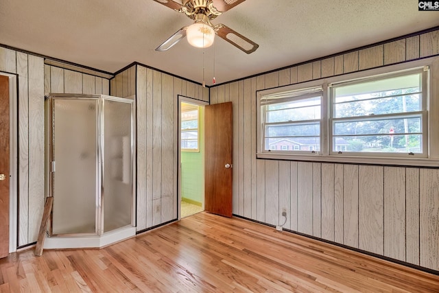 1700 Cermack St, Columbia, SC 29223 - unfurnished bedroom featuring wood finished floors, wooden walls, a textured ceiling, a closet, and a ceiling fan