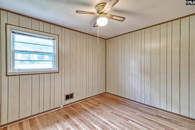 1700 Cermack St, Columbia, SC 29223 - empty room with light wood finished floors, a textured ceiling, a ceiling fan, and wooden walls