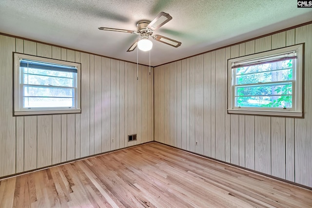 1700 Cermack St, Columbia, SC 29223 - unfurnished room featuring light wood finished floors, plenty of natural light, a textured ceiling, a ceiling fan, and wooden walls