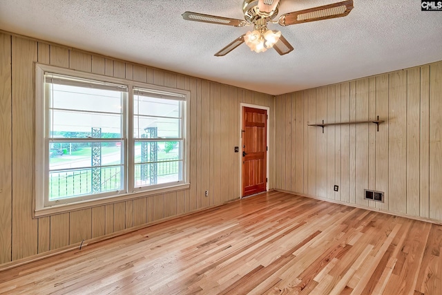 1700 Cermack St, Columbia, SC 29223 - empty room with light wood-type flooring, a textured ceiling, a ceiling fan, and wooden walls